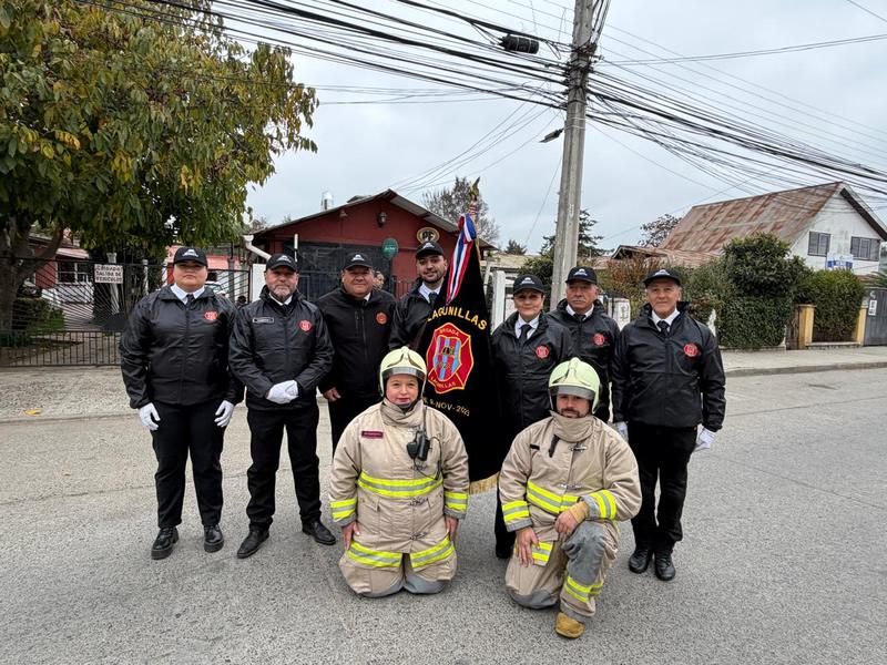 Voluntarios de la brigada en formación durante un desfile institucional, junto a su estandarte