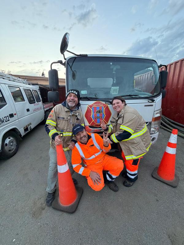 Tres voluntarios de la brigada junto al carro durante un turno de servicio